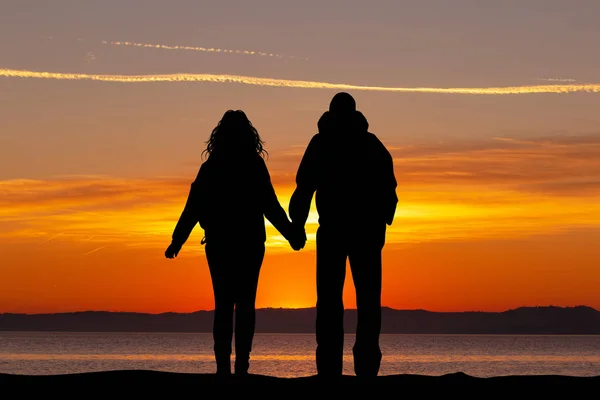 couple looking to the sea at sunset