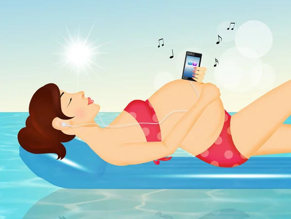 pregnant woman listens to music on the air mattress