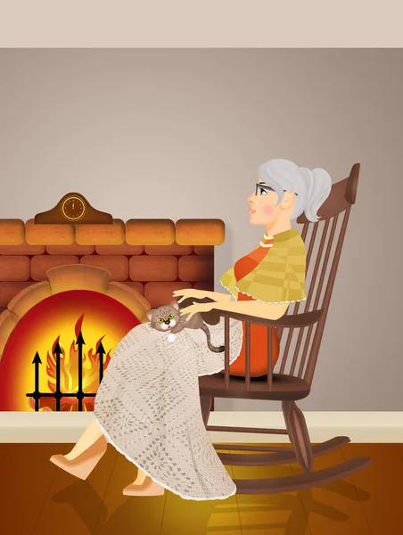 说明祖母坐在炉火前的摇椅上 — 图库照片