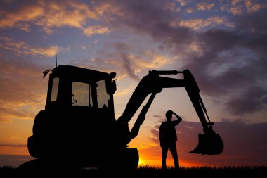 İşçi ve buldozer gün batımında