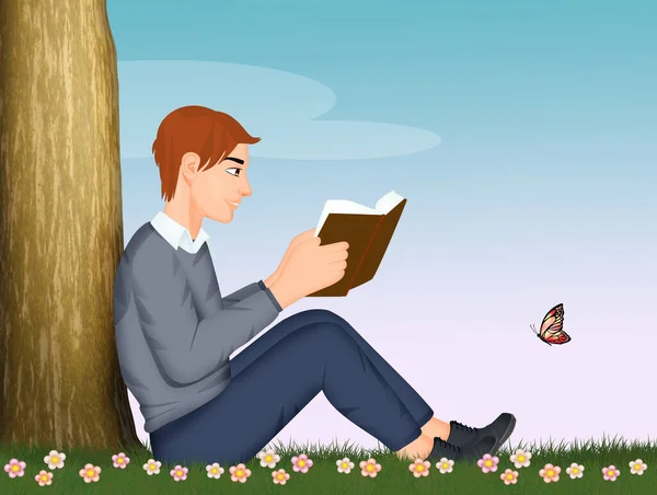 男は草の上に座って本を読み — ストック写真