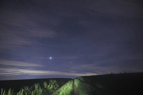 Path to the stars through a farm field with Jupitor in the sky.