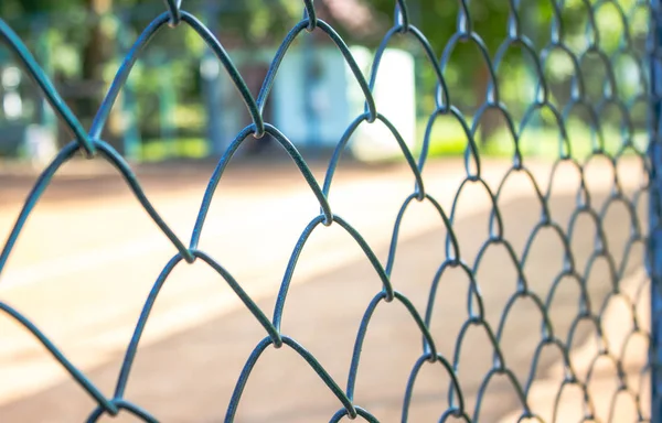 Eski çelik tel örgü çit ile arka plan bulanık yakın çekim.