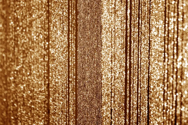 光沢のあるスレッドの作られた黄金のカーテン 抽象的なクリスマスやお正月の背景がぼやけてください — ストック写真