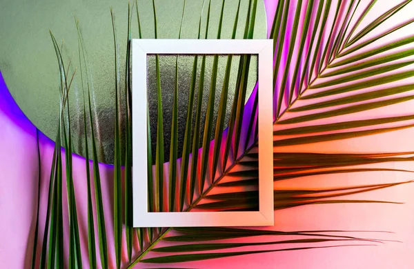 Marco blanco con hojas de palma sobre un fondo de neón de moda. Concepto de verano. Vista superior, plano . — Foto de Stock