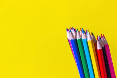 Parlak sarı arka planda renk kalemler. Okul konseptine geri dönelim. Metin için boşluk Kopyala.