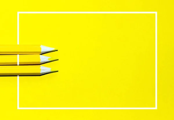 Yellow color pencils and white border on a yellow background. Top view, copy space, place for text. — Stock Photo, Image