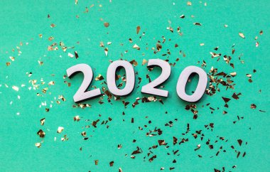 2020 beyaz ahşap harf ve nane arkaplanda altın parıltılar. Şenlikli Yeni Yıl duvar kâğıdı.