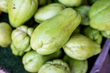 Tay pazarında meyve tepsisi zemin üzerine yeşil Chayote.