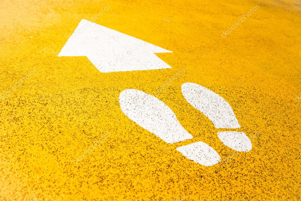 Footprints signs on yellow asphalt road colour.