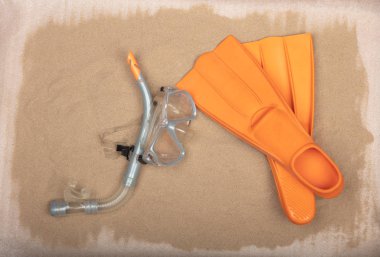 Kullanılan dalış ekipmanları turuncu dalış maske, şnorkel ve palet kumlu zemin üzerine.