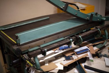 Büyük giyotin kesme kağıt ile düşük bir açıda kaldırdı bıçağı için yapılmayan dağınık atölyecilik masa üzerinde görünümü kapatın