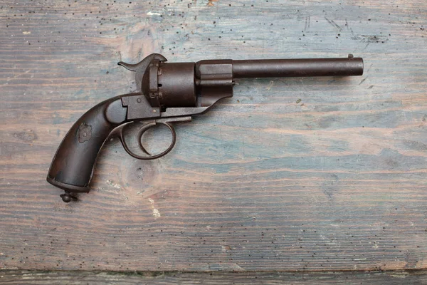 Historic gun in a museum exhibit or collectors showcase displayed on a wooden background in a close up shadowy view with copy space