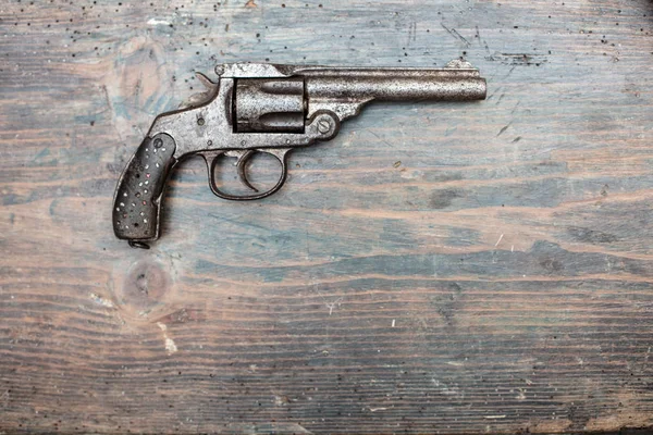 Historic gun in a museum exhibit or collectors showcase displayed on a wooden background in a close up shadowy view with copy space
