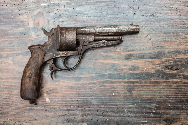 Historic gun in a museum exhibit or collectors showcase displayed on a wooden background in a close up shadowy view with copy space