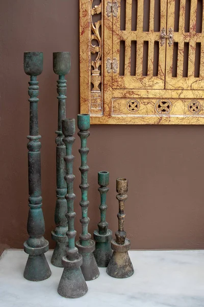 An attractive set of three varied sized pillar candle holders made form solid wood superbly hand painted as rustic metal on marble surface
