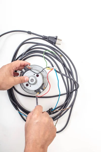 Vacuum cleaner motor  with cord and srewdriver on a white background top view