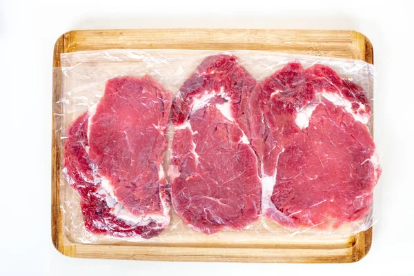 Vers Rauw Rundvlees Biefstuk Transparante Vacuüm Verpakt Houten Snijplank Geïsoleerd — Stockfoto