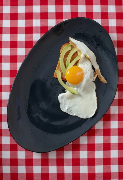 Avocado toast med stekt egg på ristet brød – stockfoto