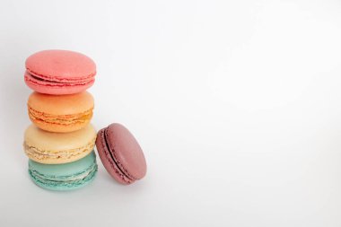 Renkli macarons kek. Küçük Fransız kek. Tatlı ve beyaz arka planda, yüksek açılı görünüş kopya alanı ile renkli Fransızca macaroons