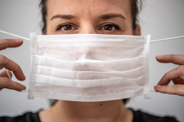 Close up portrait of beautiful brunette 30s young woman cover her face wearing facial medical  mask, anti-virus  infectious disease outbreak protection, healthcare concept