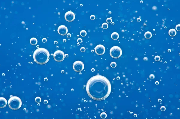 Bellen van zuurstof omhoog in blauw water. — Stockfoto