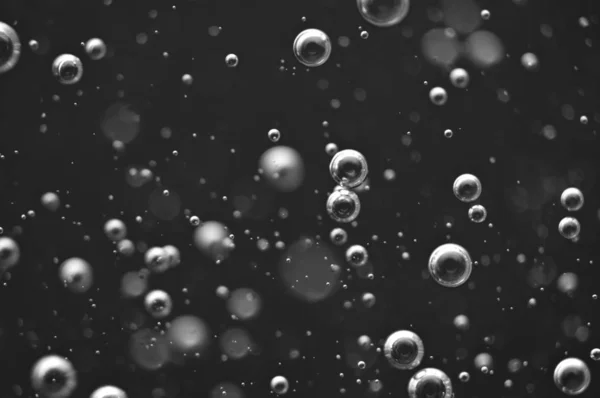 Bubblor av syre eller luft i en mörk vätska. — Stockfoto