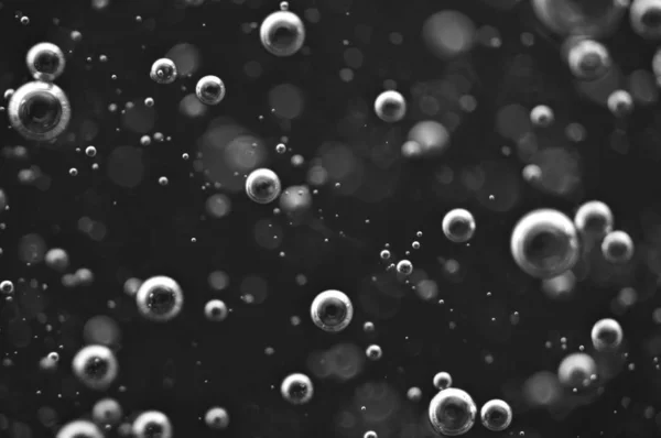 Blasen aus Sauerstoff oder Luft in einer dunklen Flüssigkeit. — Stockfoto