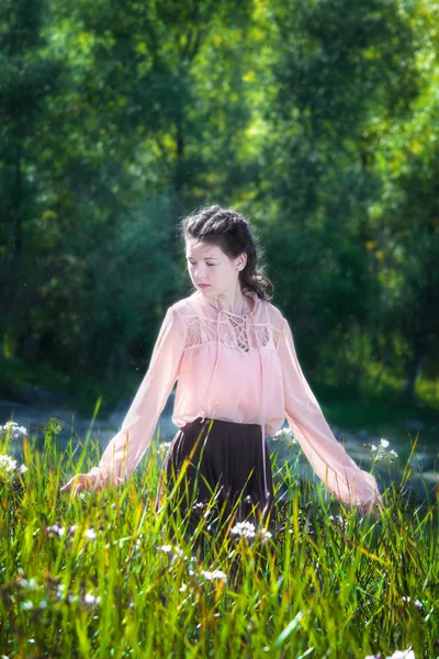 高い草で花のフィールドを歩いて 夏の晴れた日に若い女の子 — ストック写真