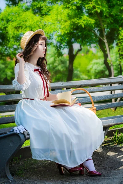 Akıllı Uzun Beyaz Elbiseli Genç Kız Bir Parkta Bankta Bir — Stok fotoğraf