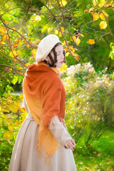 Gözleri paltosu kapalı kız ve sonbahar öğleden sonra bir yürüyüşe çıkmak, arkadan görünümü.