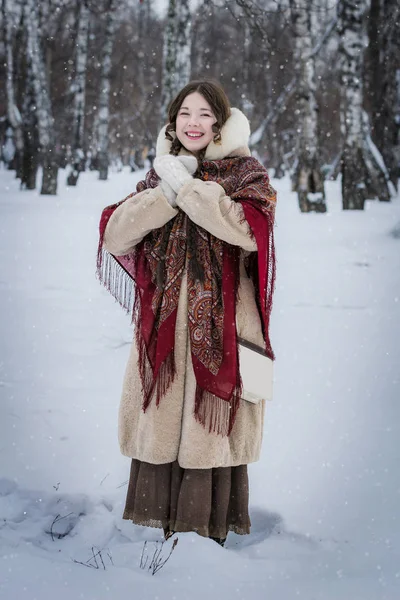 女性が木の中で雪に覆われた公園内屋外冬の寒い日で笑します — ストック写真