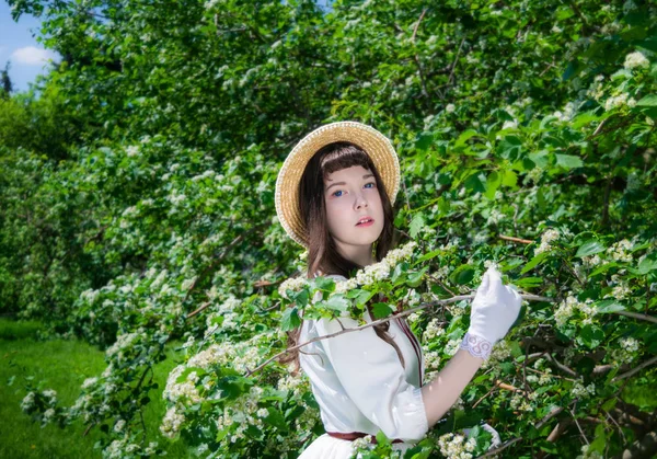 Retrato chica en un vestido blanco y sombrero de paja cerca —  Fotos de Stock