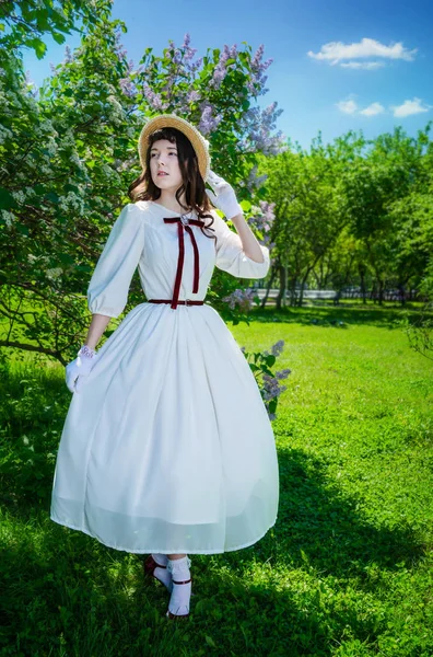 Девушка в белом платье и соломенной шляпе ходит — стоковое фото