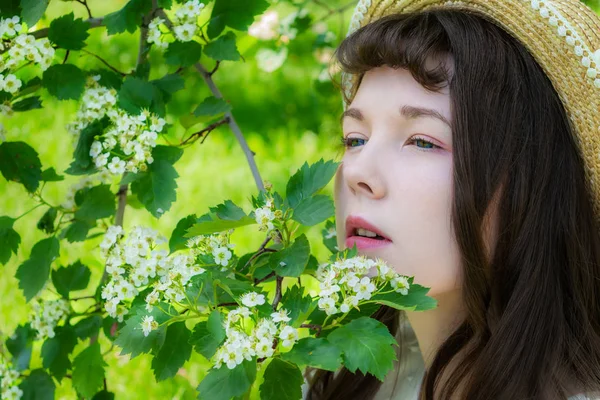 Menina em um jardim em flores de espinheiro — Fotografia de Stock