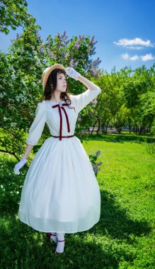 Beyaz elbise ve hasır şapka çekici kız yürüyor