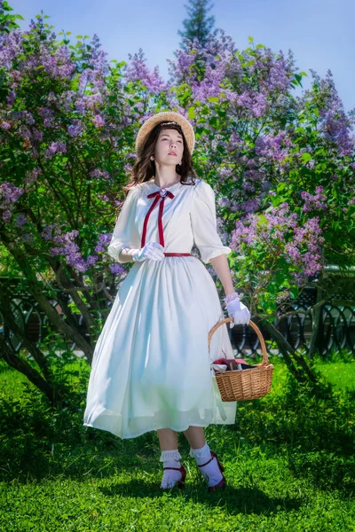 Chica con una cesta en sus manos en un paseo en el jardín —  Fotos de Stock