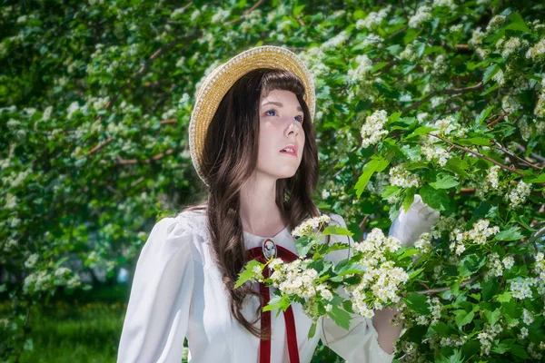 Portret charmante dame in witte jurk in de buurt van bloemen meidoorn — Stockfoto