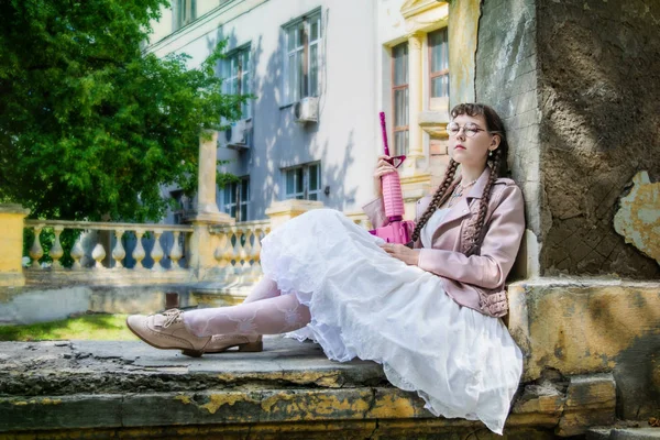 Уставшая женщина с розовой винтовкой отдыхает — стоковое фото