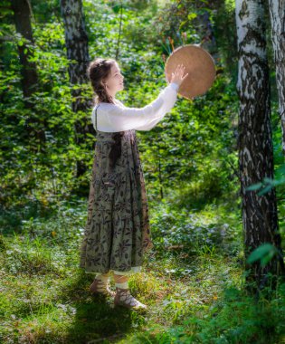 Bir büyücü bir tef ile güzel genç kadın.