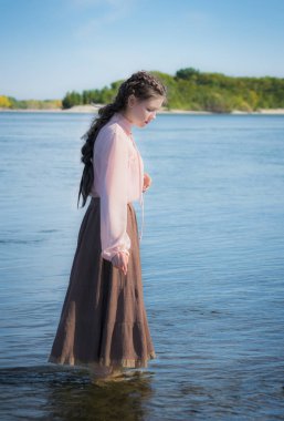 güzel üzgün kız nehirde duruyor