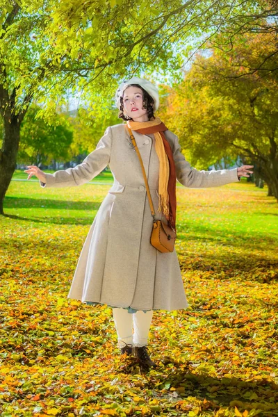 Menina em um casaco leve em um dia ensolarado de outono em um parque . — Fotografia de Stock