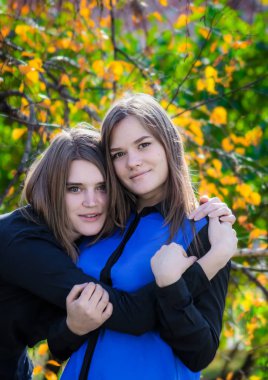 İki güzel kız arkadaş sarılıyor.