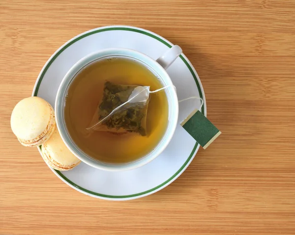 Tasse Grüner Tee Und Macaronsamen Von Oben Auf Der Arbeitsplatte — Stockfoto