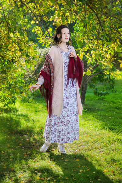 Sad women in a shawl in the park on an autumn day