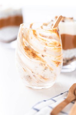 Beyaz arka planda bir bardak yoğurt, fıstık kreması ve fındık. Keto kahvaltısı.