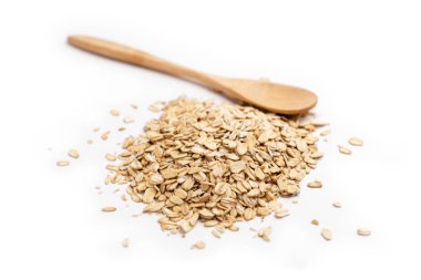 Boş bir tahta kaşık ve beyaz bir arka planda izole edilmiş bir yığın yulaf ezmesi..