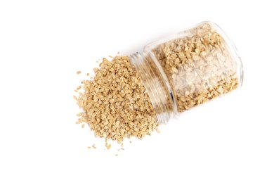 Beyaz arka planda izole bir kavanozdan düşen yulaf tanelerinin üst görüntüsü