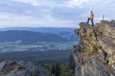 adam kayaya Kaitersberg üzerinde oturur ve mesafe içine doğana görünüyor. Kaitersberg Hill, Bavyera Ormanı.