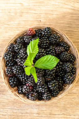 Böğürtlen kase ahşap rustik masa üzerinde. Doğal çilek.